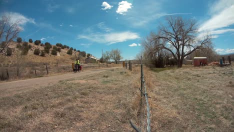 man bikepacking across countryside road through farmland, still shot