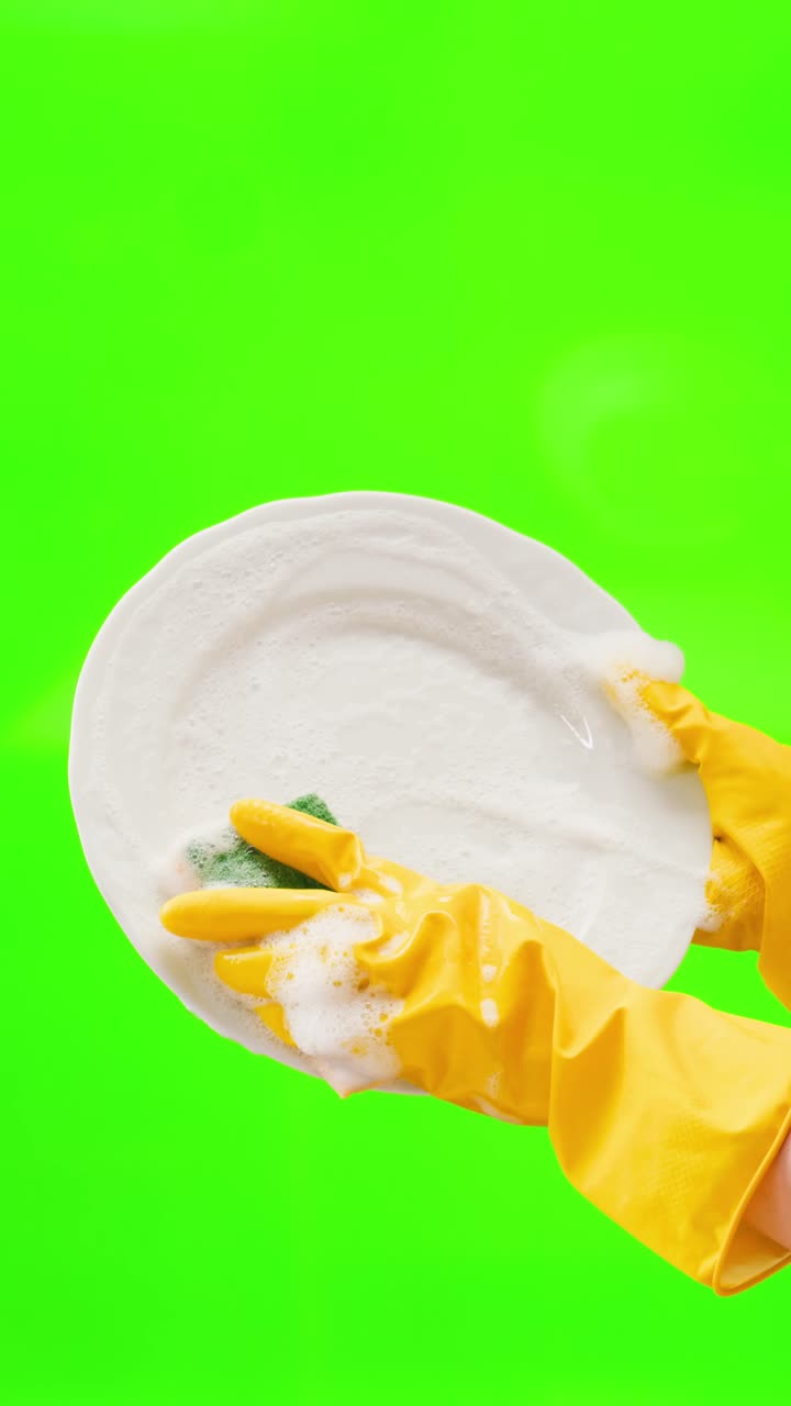 Hands in Yellow Gloves Washing a White Plate with Soap Suds