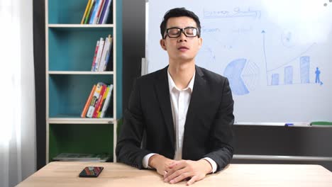 asian businessman looking at camera talking about business plan