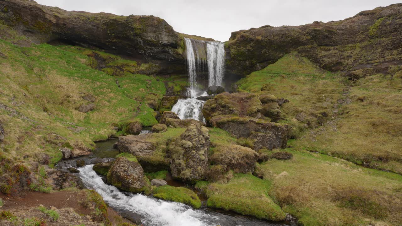una hermosa cascada que fluye fuertemente en un día nublado en islandia