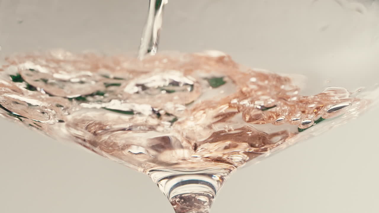 Orange or white wine bottle and glass against a sunset in a peaceful vineyard, pouring of ecological natural wine.