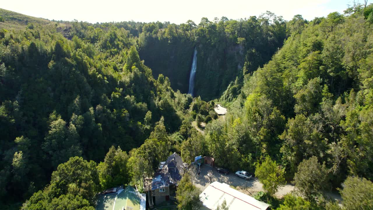 Dolly in flyover of the Tocoihue waterfall, hidden in a natural space full of greenery, sunny day in Chiloé, Chile