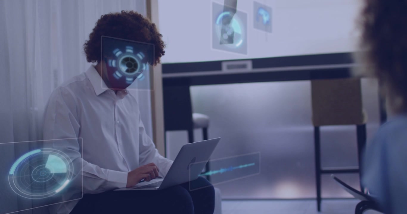 Siddende mand taster på bærbar computer, initierer holografisk brugerflade, HUD'er cirkler omkring ansigtet, mens han tester AR-dashboard.