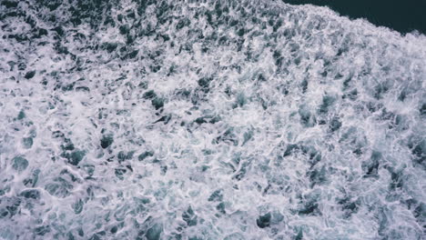 slow motion aerial shot overhead a freshly broken wave at the seaside