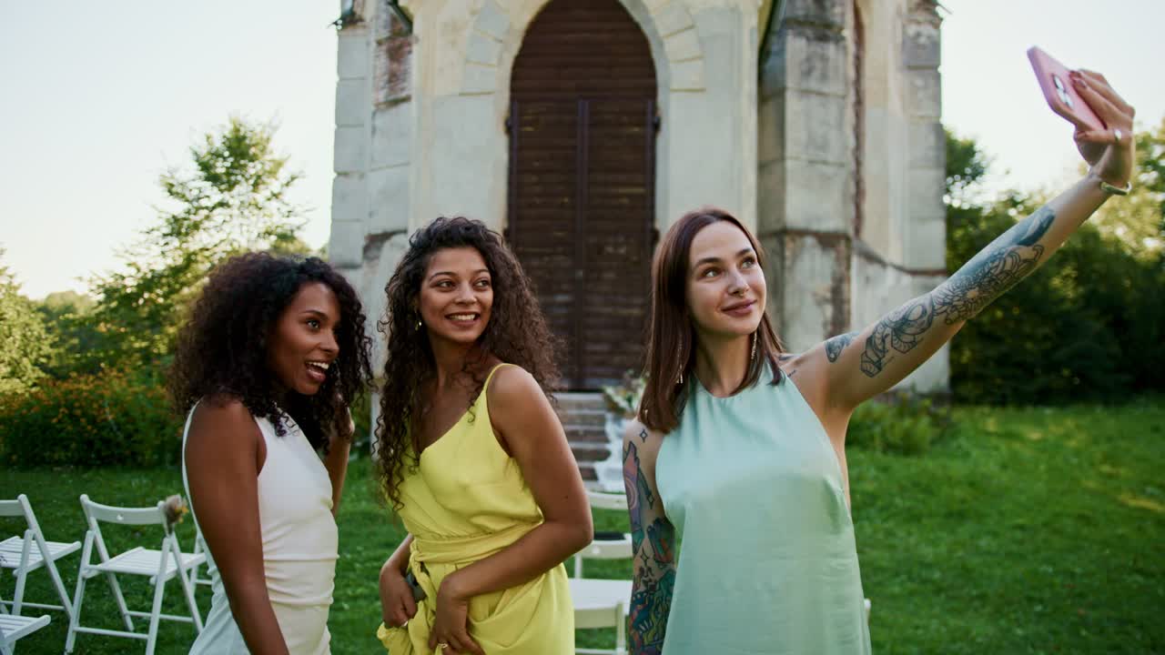 Friends taking a selfie at an outdoor wedding