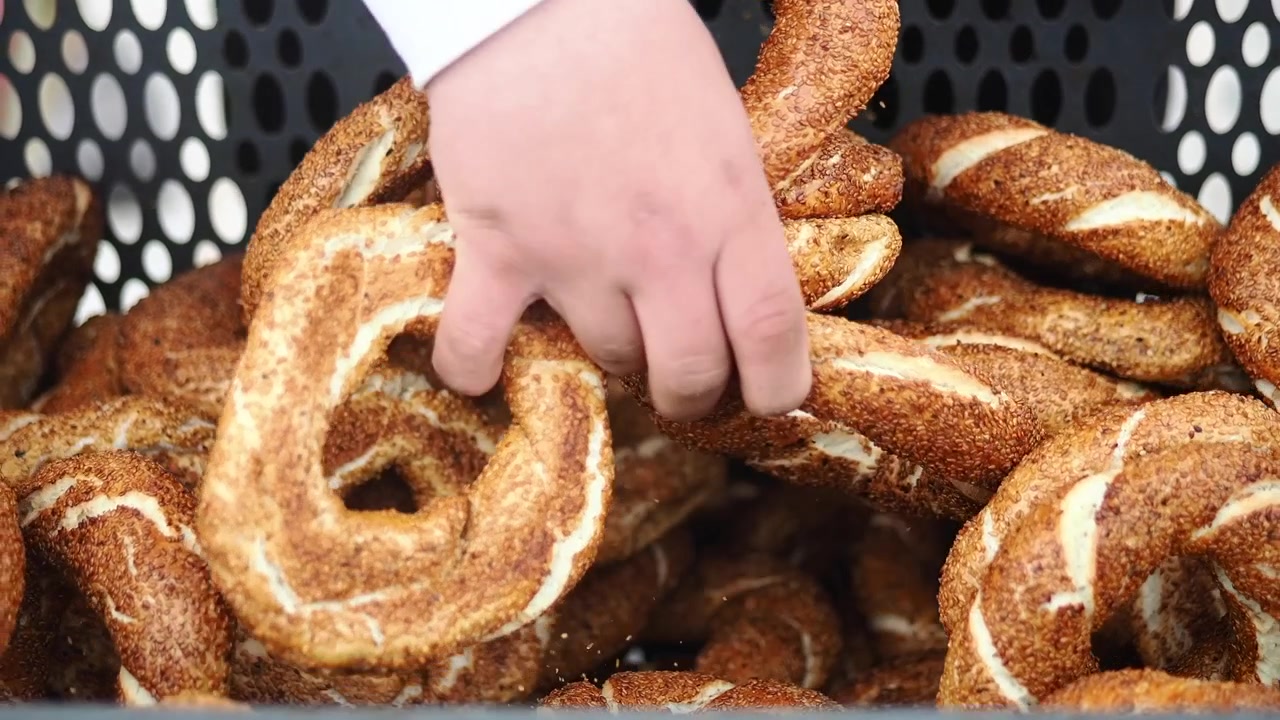 Hand Picking a Fresh Simit from a Basket