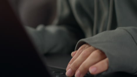 close up on hands of anxious woman sitting indoors on sofa working from home using laptop typing worried about cost of living crisis