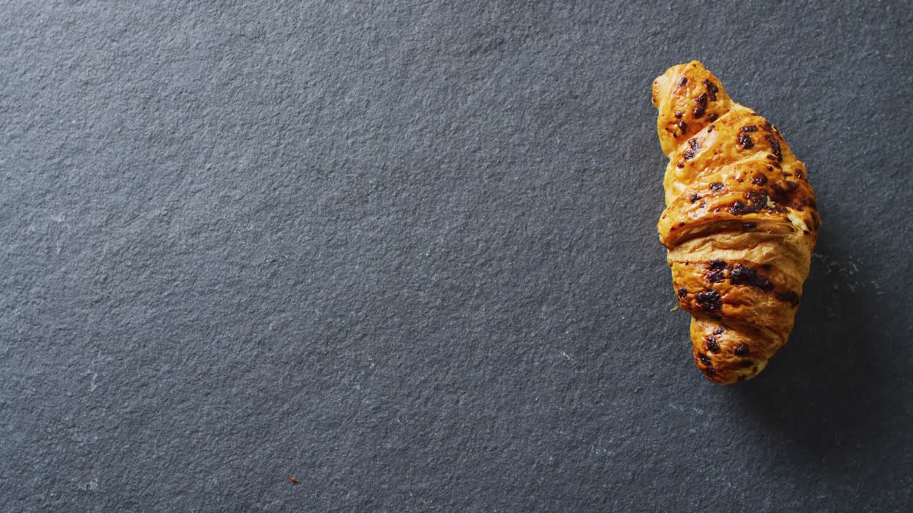video de primer plano de un croissant sobre un fondo gris