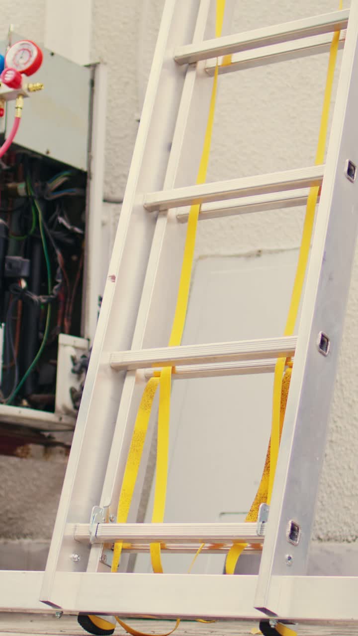 Vertical video Electrician climbing folding ladder