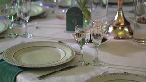 mesa de madera decorada para un banquete, con cubiertos, platos de cerámica y copas de vidrio