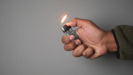 hand holding a lighter with flame