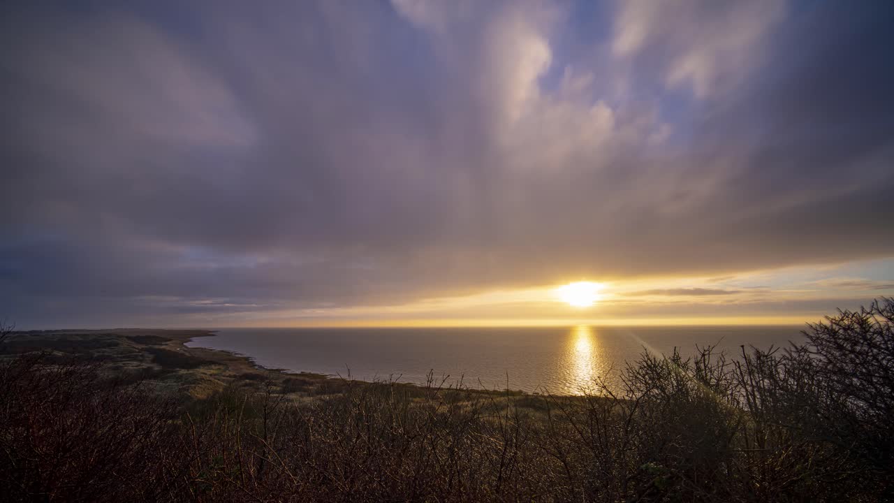 lapso de tiempo de la puesta de sol en ameland, isla holandesa de las islas wadden, países bajos, desde la duna más alta, montaña marina