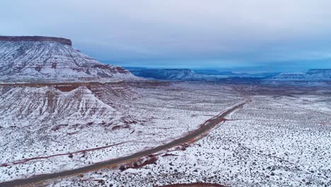 Drone-Aéreo-Disparado-Por-Encima-De-Una-Carretera-En-El-Desierto-Cubierto-De-Nieve