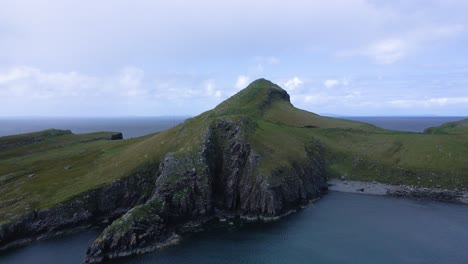 drone shot flying towards neist point on the isle of skye in the scottish highlands.