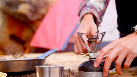 man igniting mini gas stove with lighter 4k