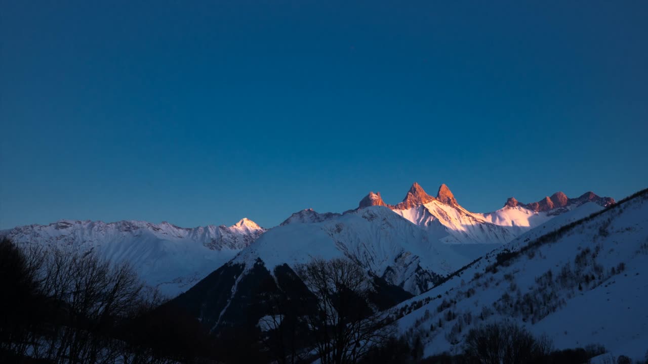 Timelapse: tramonto sulle lontane Aiguilles d'Arves, una catena montuosa innevata in Savoia, Francia. Vista dalle località sciistiche Les Sybelles