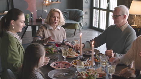 familia feliz brindando entre sí mientras cenan juntos en casa