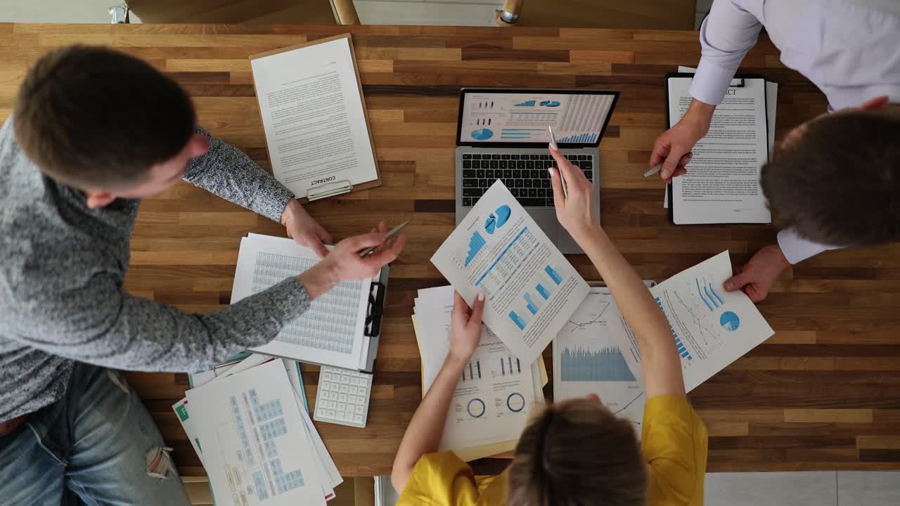 Overhead View of Business Professionals Collaborating on Data Analysis and Reports