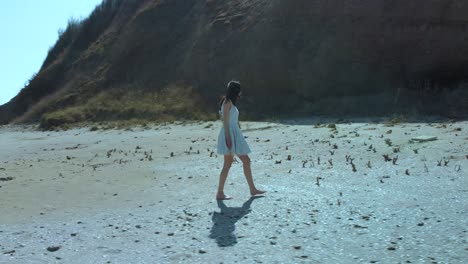 Toma-En-Cámara-Lenta-De-Una-Chica-Guapa-Con-Vestido-Blanco-Caminando-Por-La-Playa-3