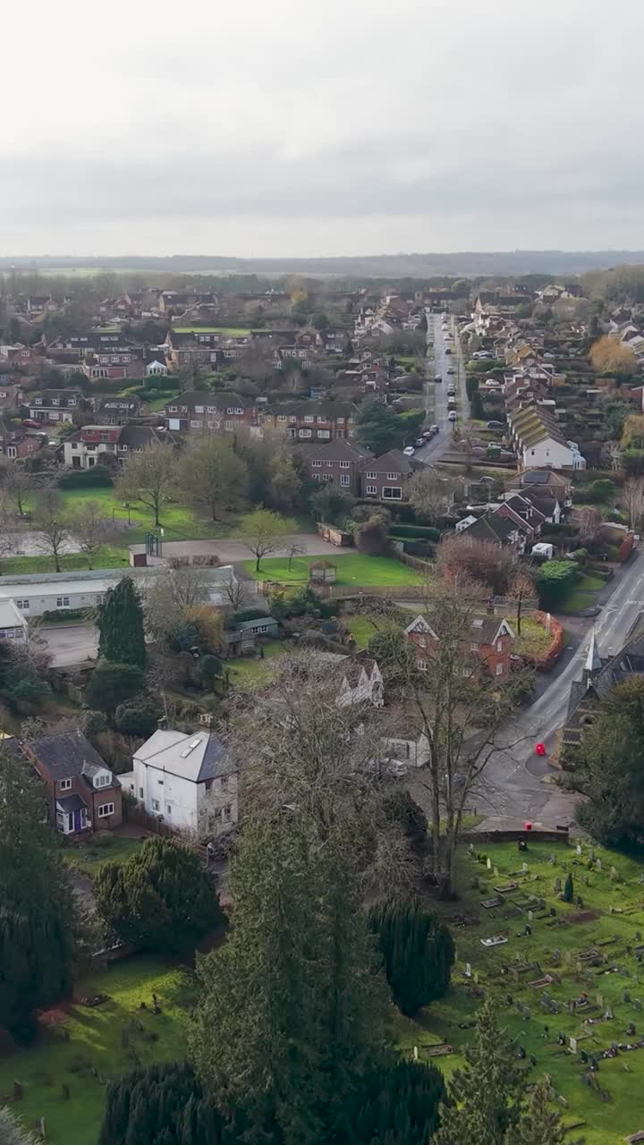 Lodret nedadgående dronebane over Wheathampstead skole og Church Street, Hertfordshire, England, med hovedvej, sportspladser og lokale huse.
