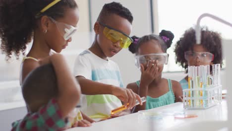 Video-of-happy-african-american-pupils-doing-experiment-during-chemistry-lesson