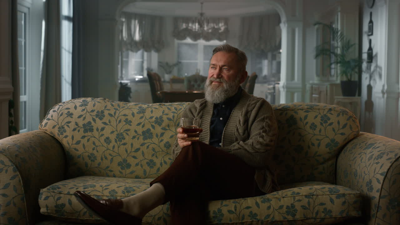 Old aged man relaxing with glass whiskey. Rich man thinking retirement life