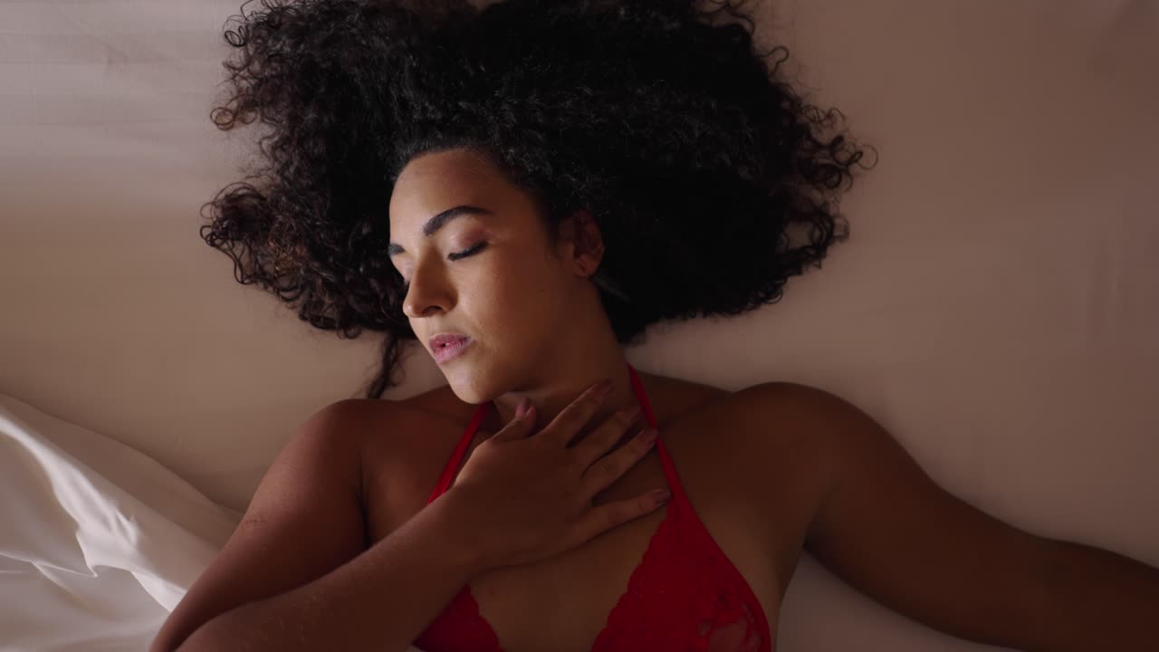 Woman with curly hair sleeping peacefully in bed