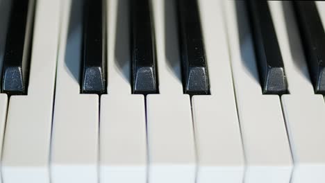 piano keys in a close up, medium speed, tracking shot from left to right