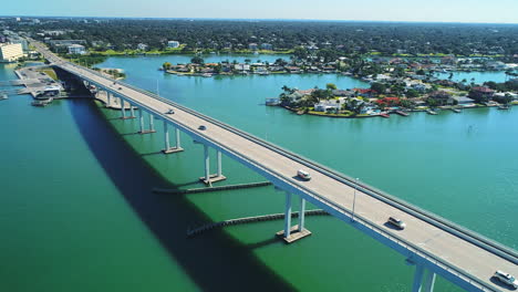 Drone-Aéreo-Volando-Un-Semicírculo-Alrededor-Del-Puente-Belleair-Frente-A-La-Playa-De-Clearwater,-Florida