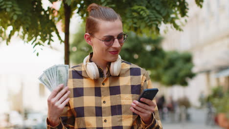 happy rich man counting holding money dollar cash use smartphone mobile calculator app online order