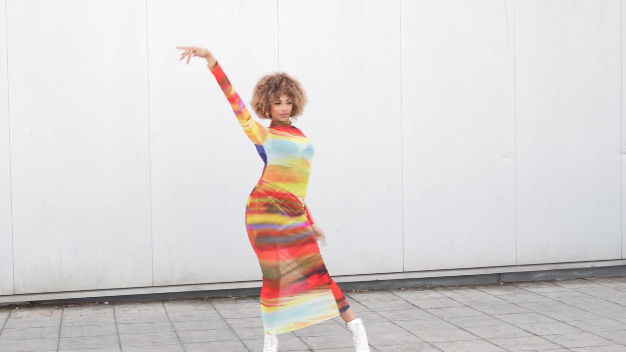 Vibrant fashion pose wearing a colorful dress in a lively urban setting and background