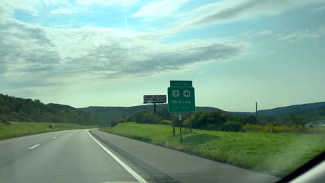 Driving-and-passing-a-road-sign-for-McGraw,-New-York