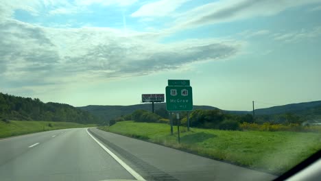 driving and passing a road sign for mcgraw, new york