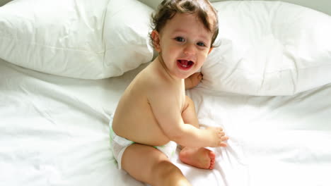 un bebé lindo jugando en una cama