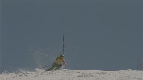 a skier skis around poles hitting one and continues down a slope