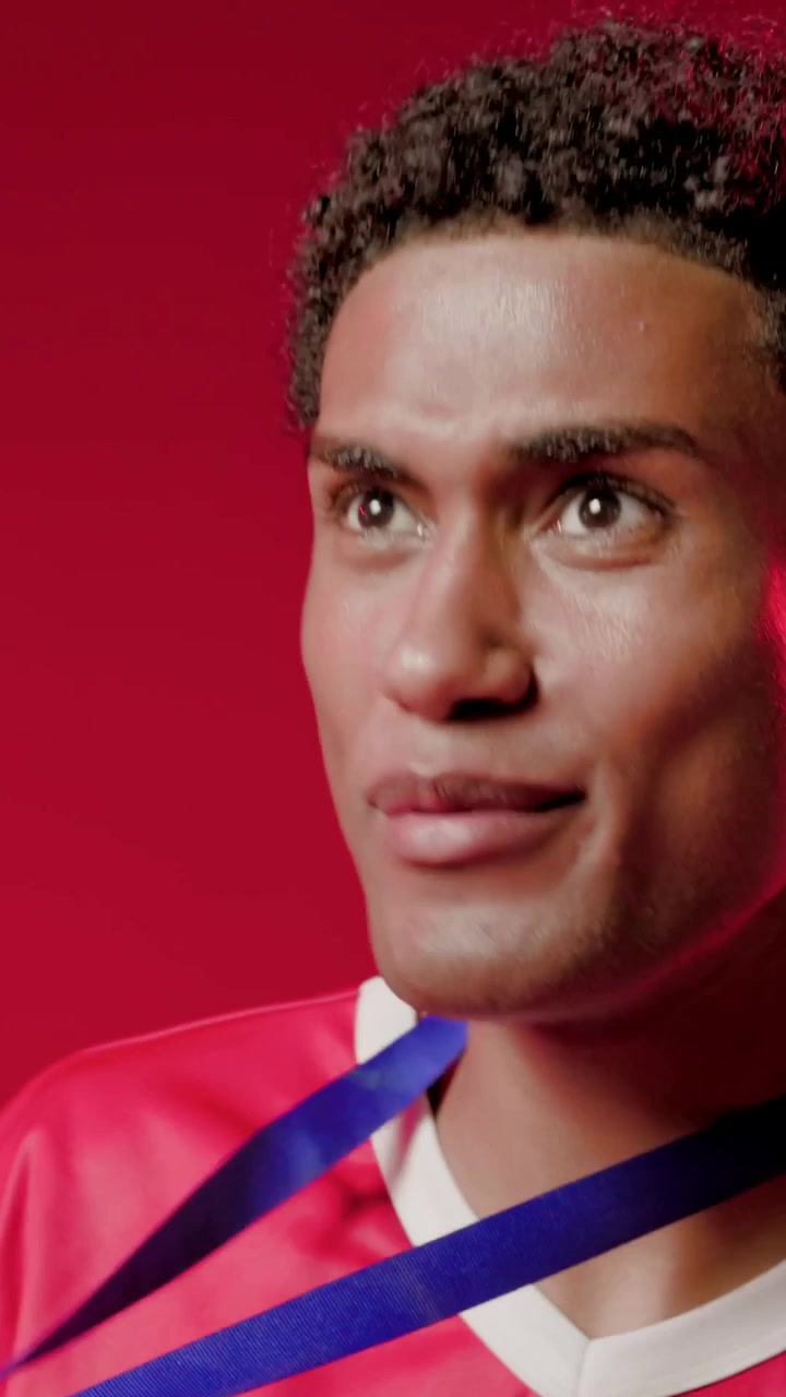 Vídeo vertical: Fita azul entrando, atleta com camisa vermelha mordendo medalha após vitória em estúdio, espaço para texto.