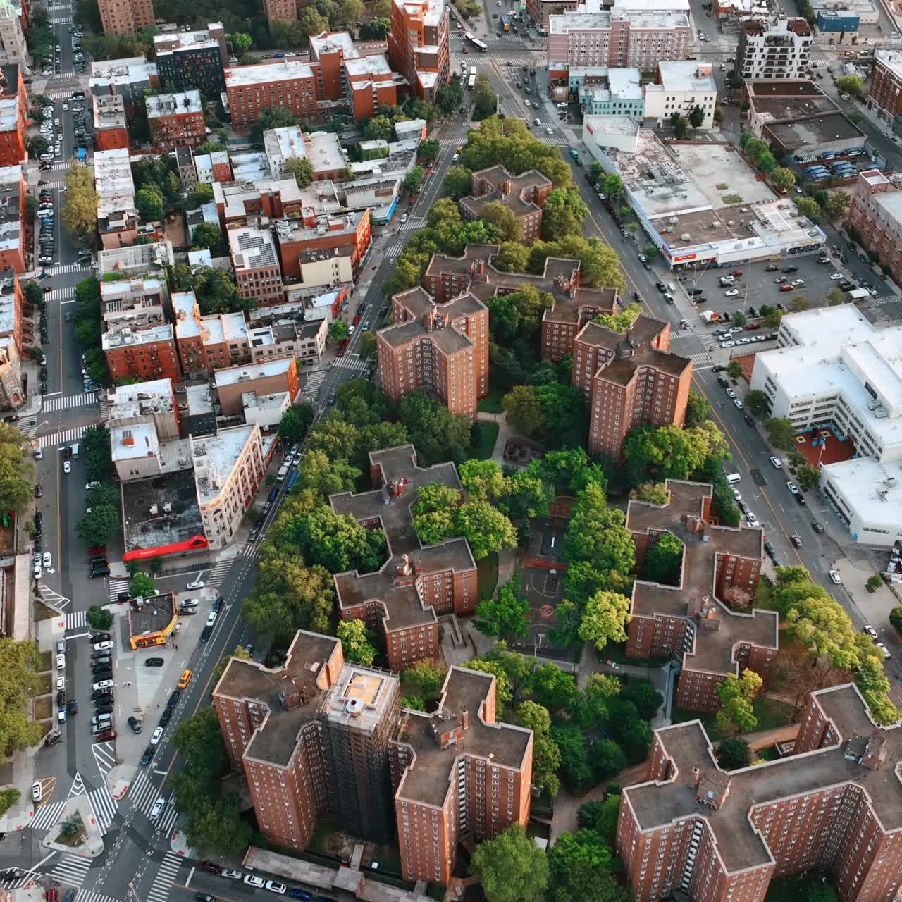 Triangle neighborhood with unusually shaped brick buildings among the greenery. New York scenery from top