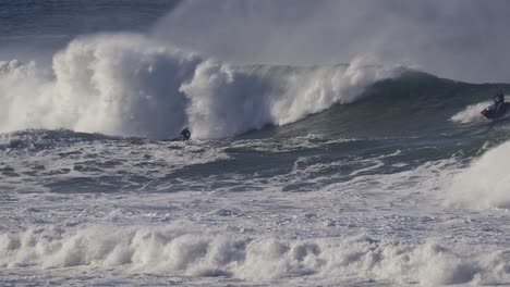 a surfer rides into a barrel created by a huge wave that eventually overwhelms him