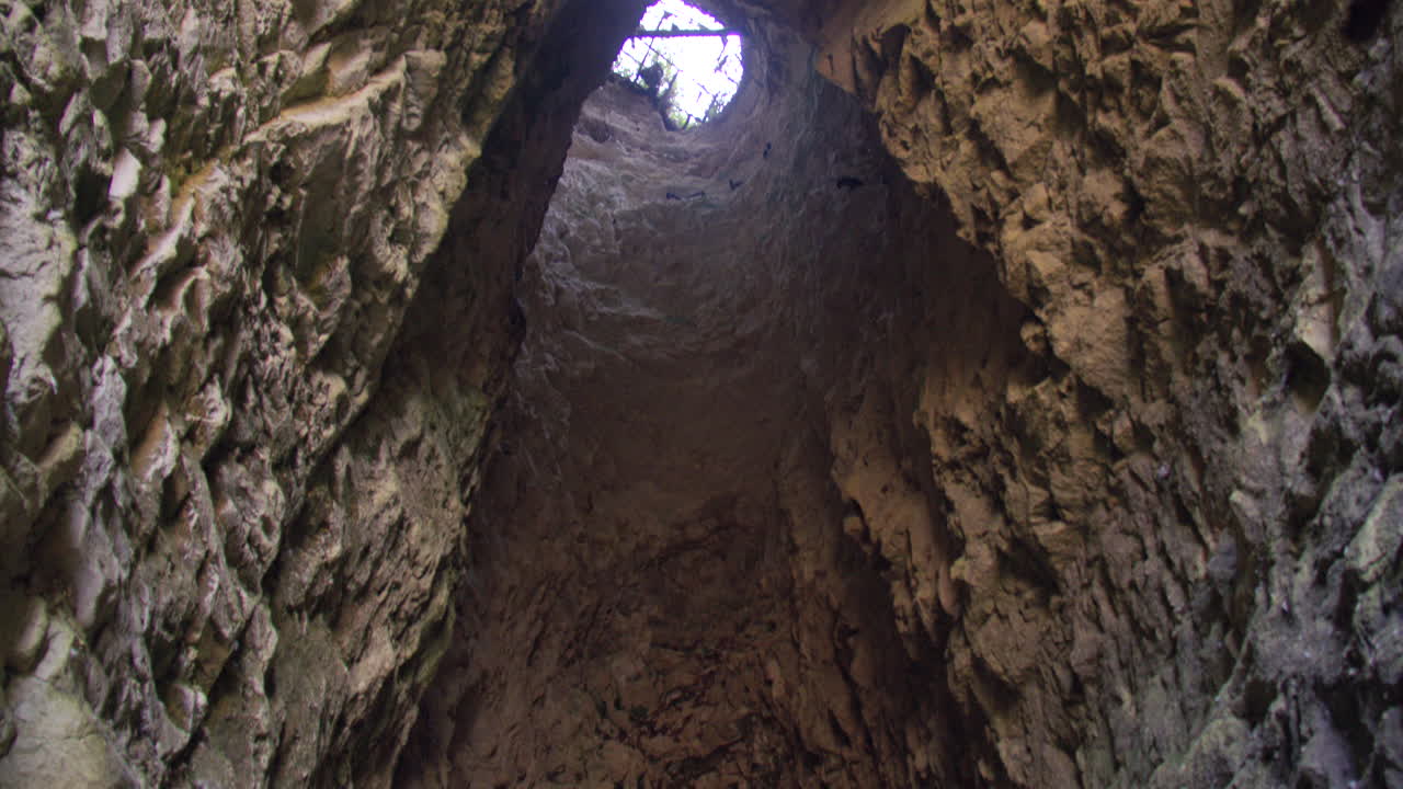 Inquadratura dal basso di un foro di luce in una grotta tra le scogliere di gesso nella baia di Kingsgate, con la bassa marea.