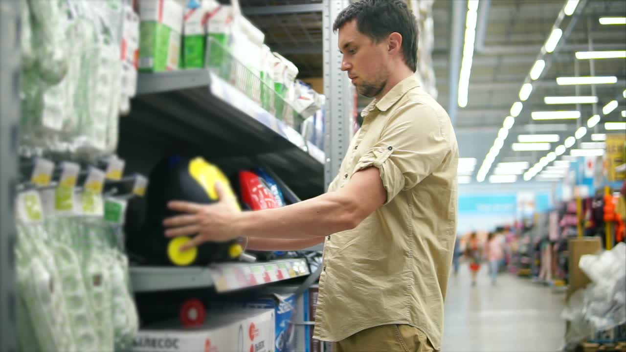 Uomo che acquista un aspirapolvere in un supermercato