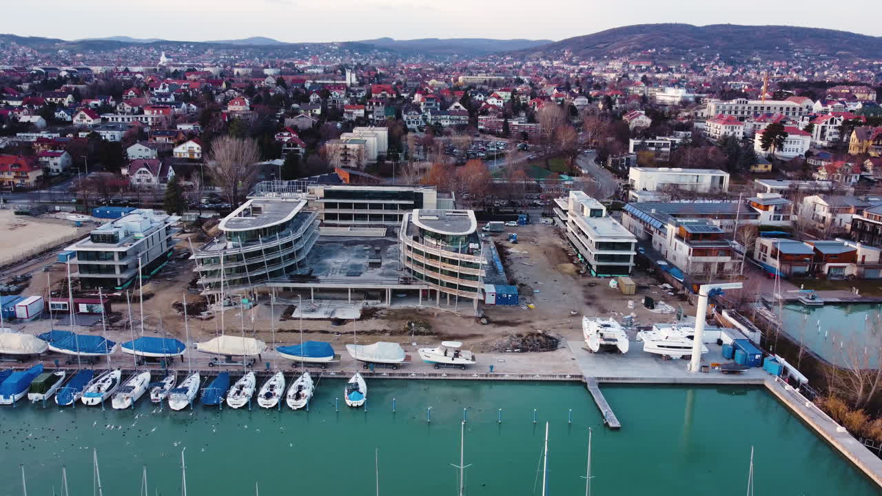 Overhead drone shot of marina boats and buildings in Balatonfured during golden hour