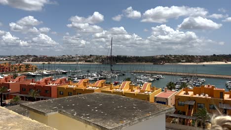 panoramic shot of port with boats in portimao city at praia da rocha during sunny day, portugal