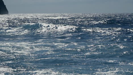 slow motion shot as midday waves break off the coast of madeira, portugal