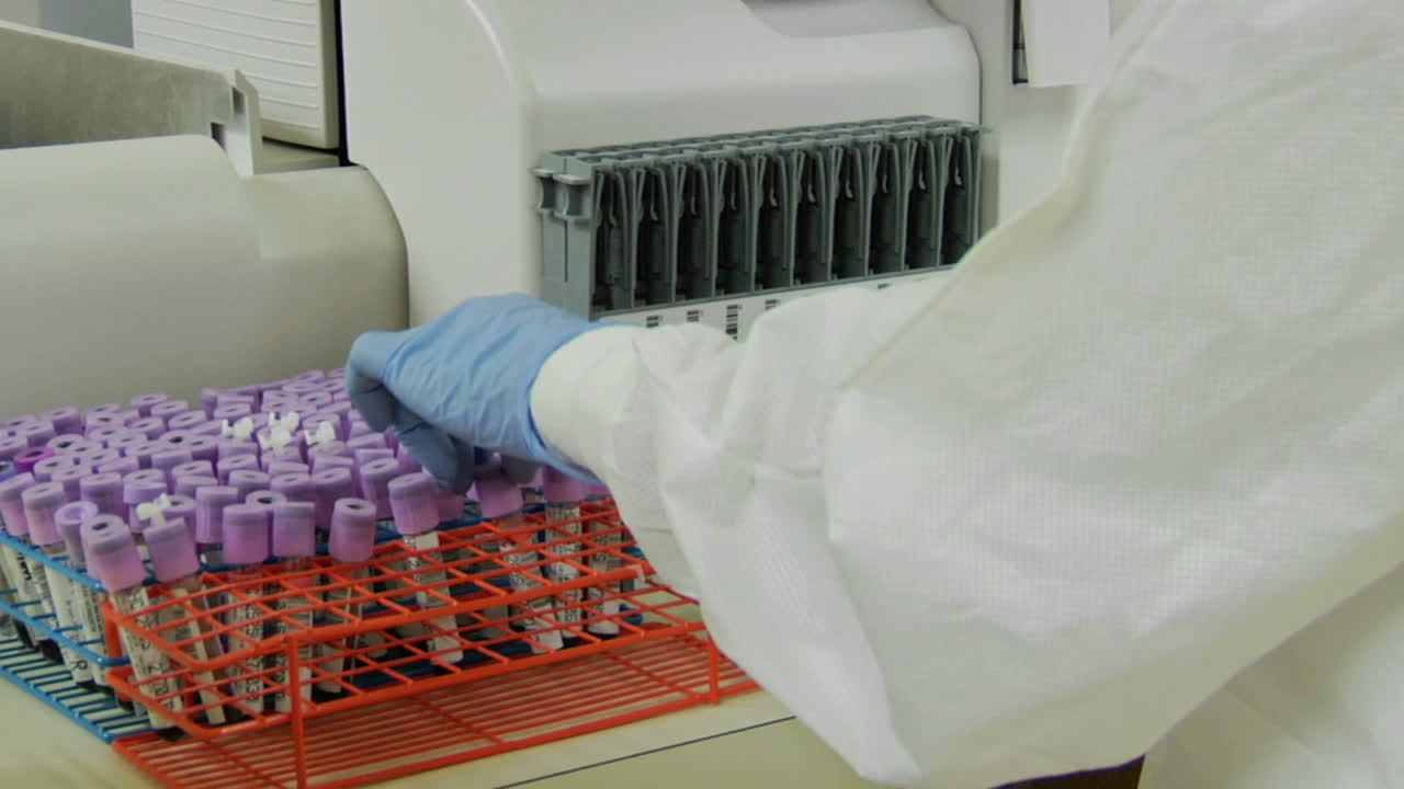 un técnico médico coloca viales de muestra en un estante