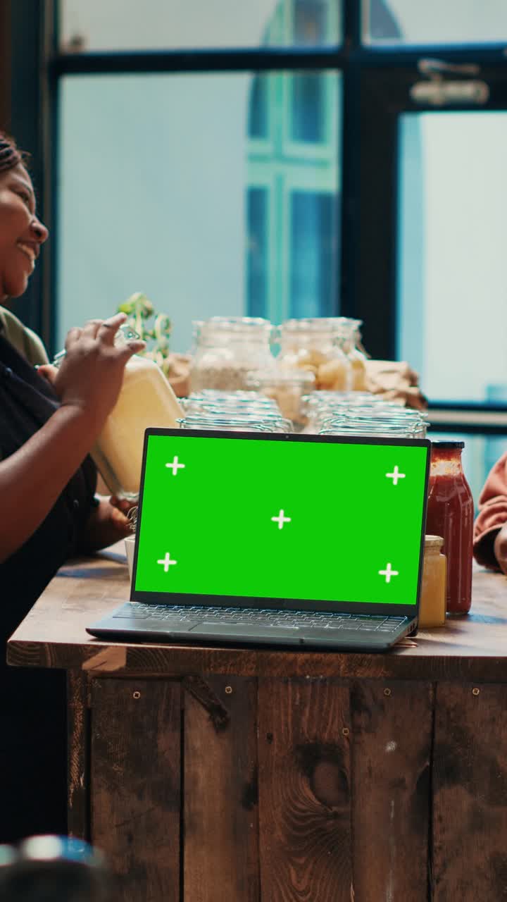 Venditrice di video verticali che presenta la sua merce accanto a un greenscreen su un PC