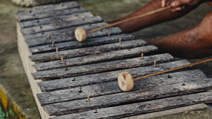 Man playing traditional Balinese musical instrument bamboo xylophone in Bali, Indonesia