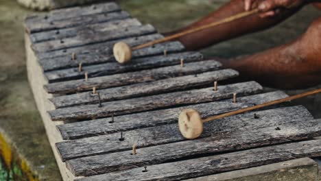 Man playing traditional Balinese musical instrument bamboo xylophone in Bali, Indonesia