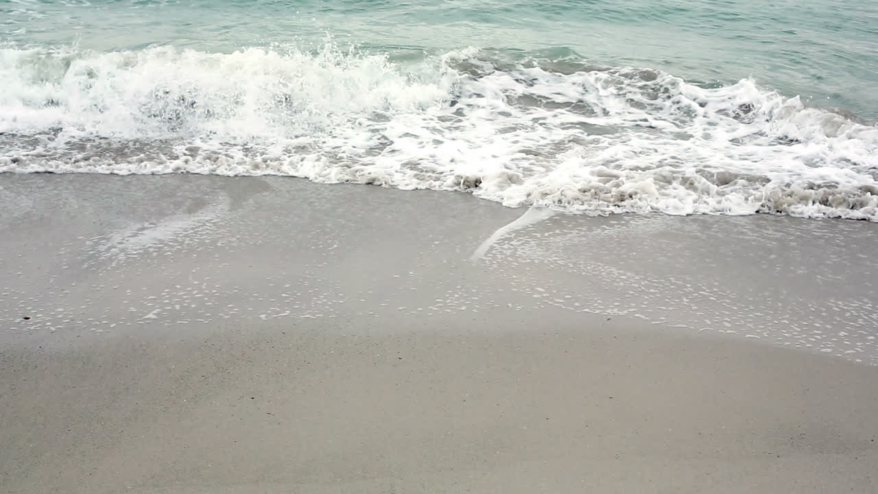 바다가 해변을 가로질러 굴러오고