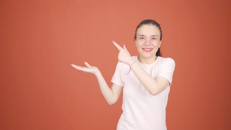 the woman promoting is pointing to the side and laughing.