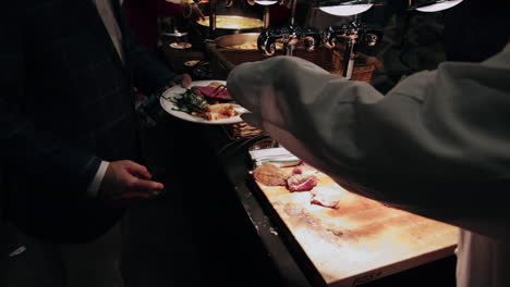 meat carved by chef in a buffet in slow motion